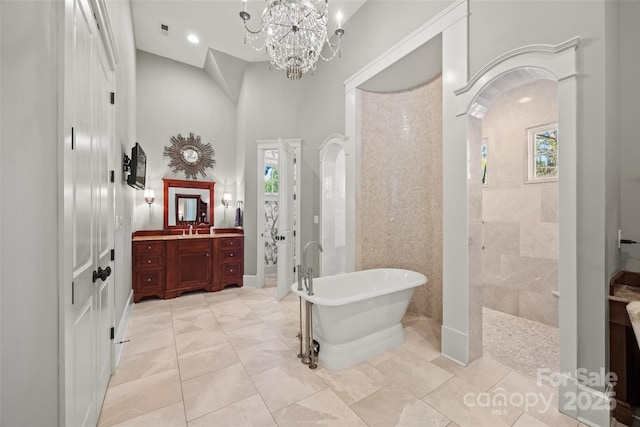 bathroom with shower with separate bathtub, a towering ceiling, a chandelier, tile patterned flooring, and vanity