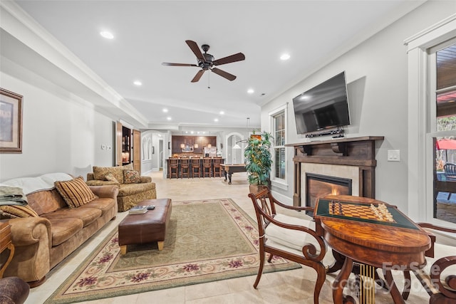 living room with light tile patterned flooring, ceiling fan, and ornamental molding