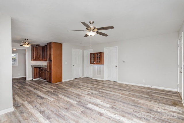 unfurnished living room featuring ceiling fan and light hardwood / wood-style flooring