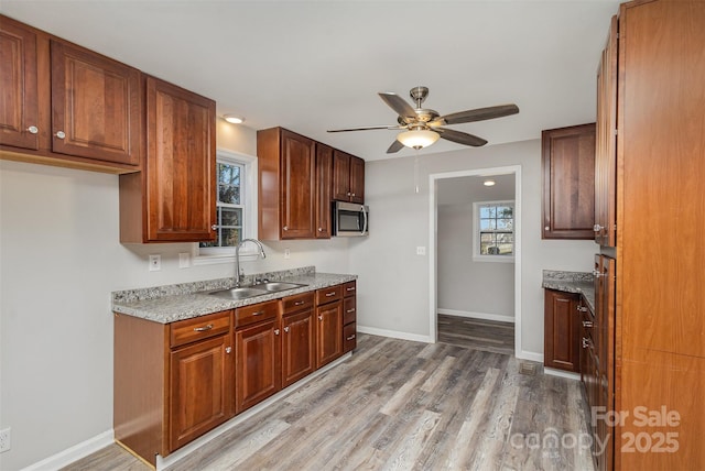 kitchen with ceiling fan, wood-type flooring, and sink