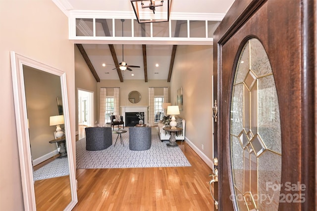 entrance foyer featuring hardwood / wood-style flooring, ceiling fan, and beamed ceiling