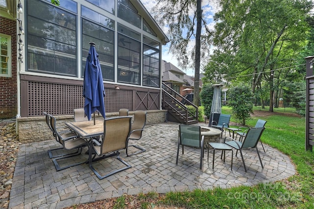 view of patio featuring a sunroom and an outdoor fire pit