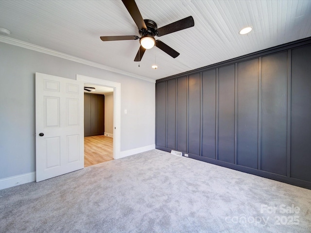 unfurnished bedroom featuring light carpet, crown molding, and ceiling fan