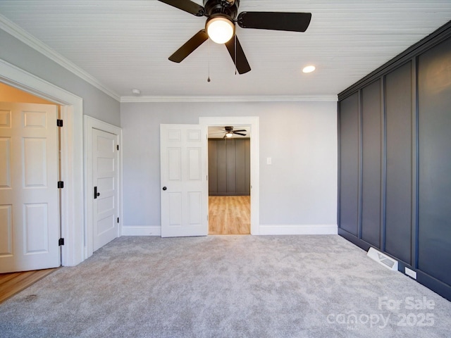 unfurnished bedroom with light carpet, crown molding, and ceiling fan