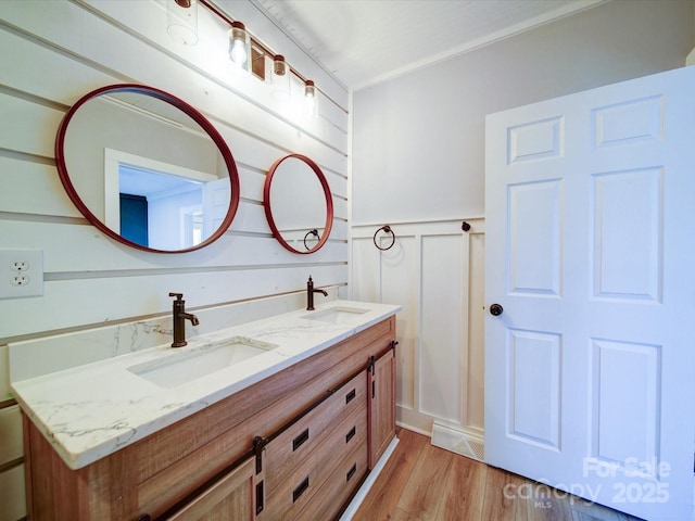 bathroom with vanity, hardwood / wood-style floors, and ornamental molding