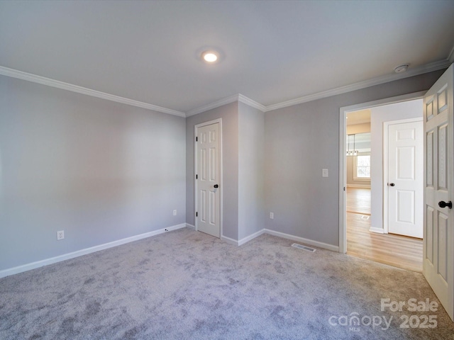 spare room with light colored carpet and ornamental molding