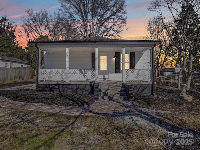 view of front facade with covered porch and a lawn