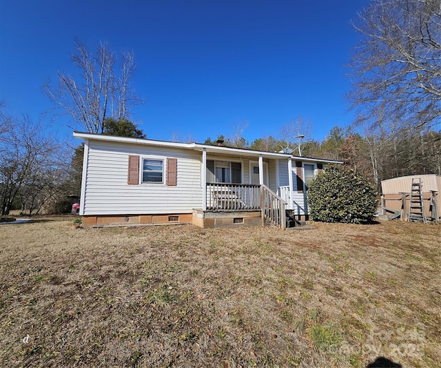 manufactured / mobile home featuring a porch and a front lawn