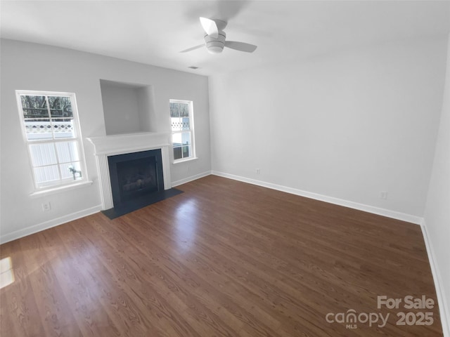 unfurnished living room featuring dark hardwood / wood-style floors and ceiling fan