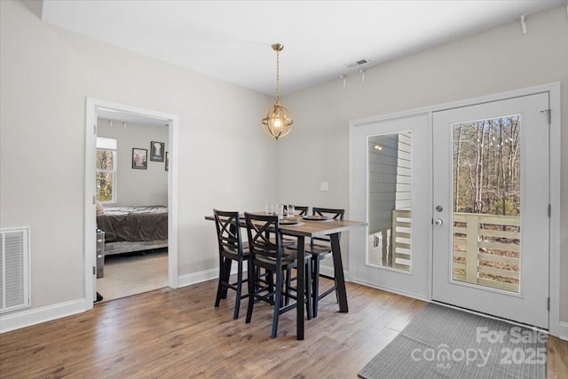 dining space featuring wood-type flooring and french doors