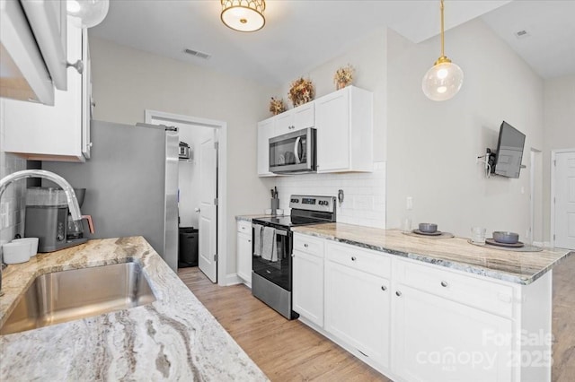 kitchen with sink, decorative light fixtures, tasteful backsplash, white cabinetry, and stainless steel appliances