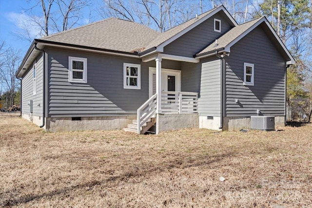 view of front of house with central AC and a front yard