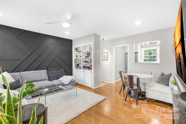 living room with ceiling fan and light hardwood / wood-style flooring