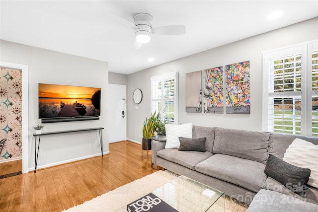 living room with wood-type flooring and ceiling fan