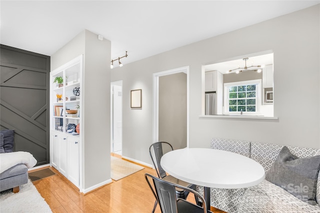 dining space featuring light wood-type flooring, built in shelves, and breakfast area