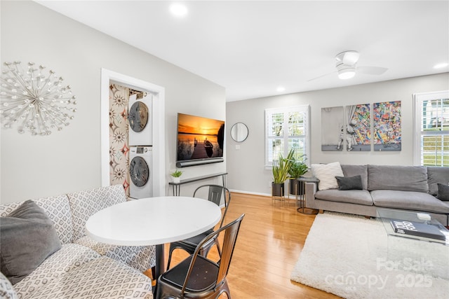 dining area with ceiling fan, stacked washer and dryer, and hardwood / wood-style flooring