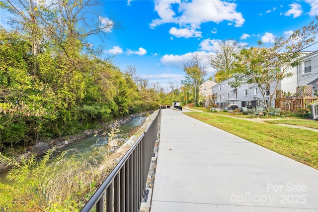 view of property's community featuring a lawn and a water view