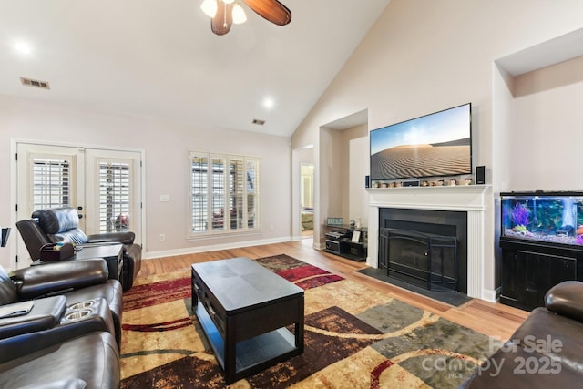 living room featuring wood-type flooring, ceiling fan, high vaulted ceiling, and french doors