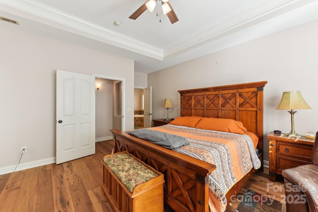 bedroom with crown molding, wood-type flooring, a raised ceiling, and ceiling fan