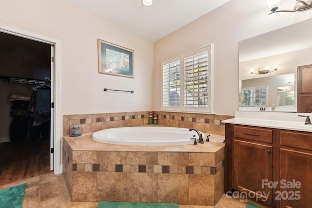 bathroom with vanity, tiled tub, and tile patterned floors