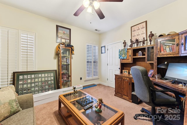 carpeted home office featuring ceiling fan