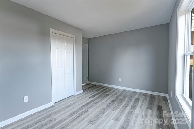 unfurnished bedroom featuring light hardwood / wood-style flooring and a closet