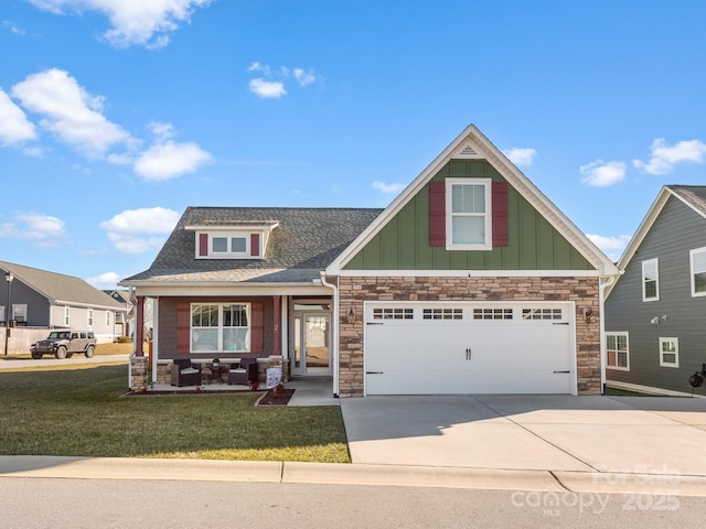 craftsman inspired home featuring a porch, a front yard, and a garage