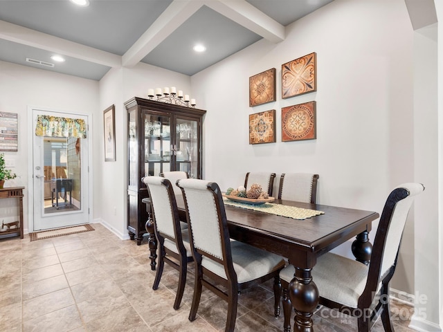 tiled dining space featuring beamed ceiling