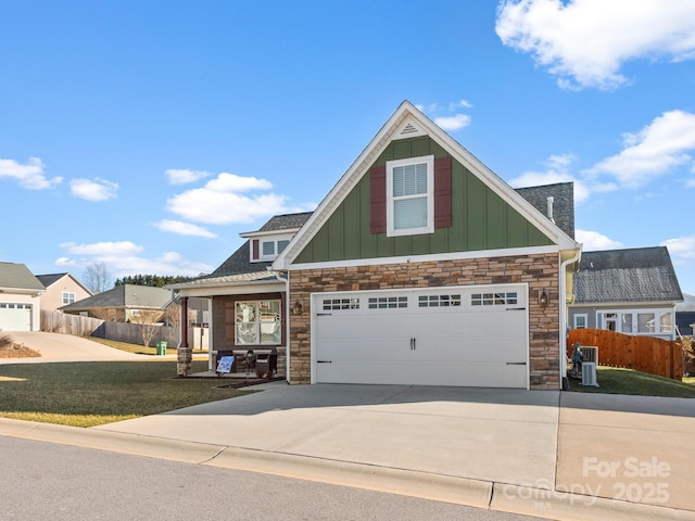 craftsman-style house with central AC, a front yard, and a garage