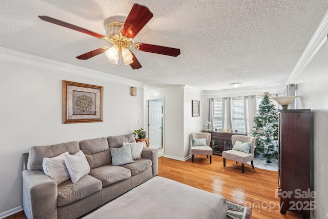 living room featuring a textured ceiling, ceiling fan, wood-type flooring, and crown molding