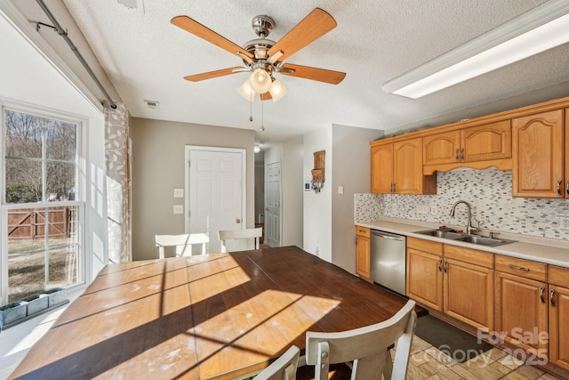 kitchen featuring decorative backsplash, stainless steel dishwasher, a textured ceiling, ceiling fan, and sink