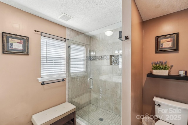 bathroom featuring a textured ceiling, toilet, and an enclosed shower