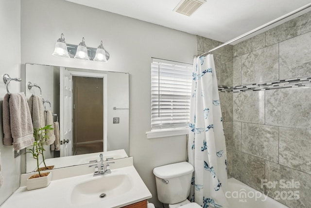 full bathroom with shower / tub combo with curtain, vanity, and toilet