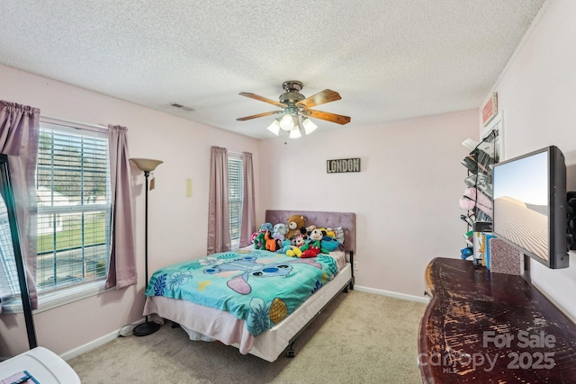 carpeted bedroom with ceiling fan and a textured ceiling