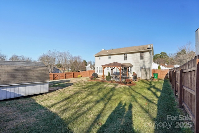 rear view of house featuring a gazebo, a yard, and a shed