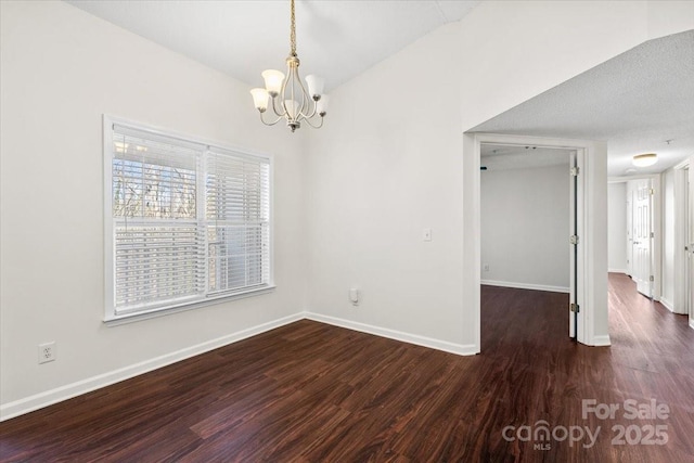 unfurnished room with a textured ceiling, dark hardwood / wood-style floors, and an inviting chandelier