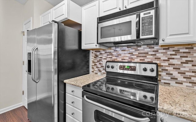 kitchen featuring decorative backsplash, white cabinets, light stone counters, and appliances with stainless steel finishes