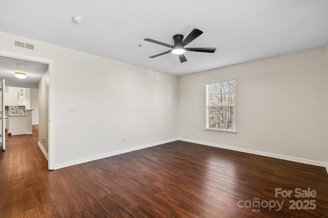 empty room featuring ceiling fan and dark wood-type flooring