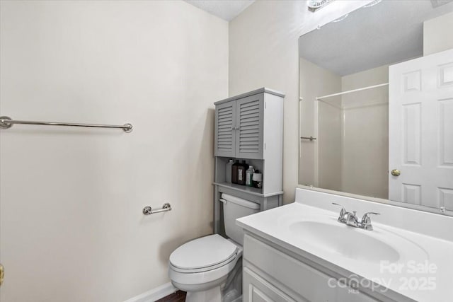 bathroom with vanity, toilet, and walk in shower