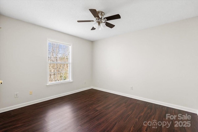 empty room with ceiling fan and dark hardwood / wood-style flooring