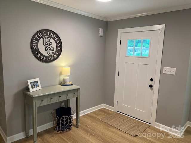 foyer entrance with ornamental molding and light wood-type flooring