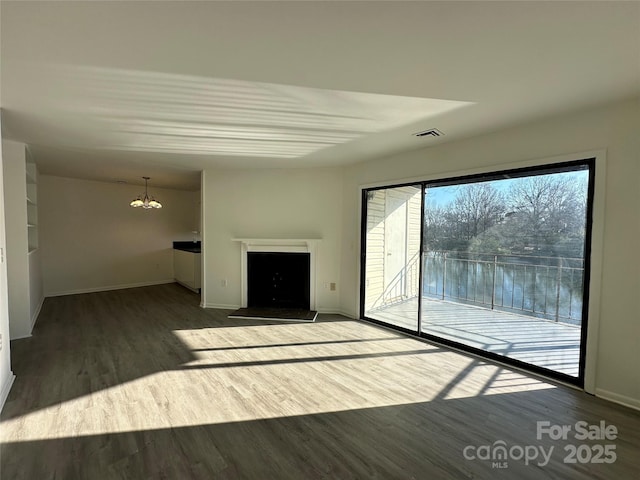 unfurnished living room featuring a chandelier and wood-type flooring