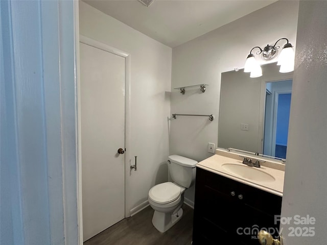 bathroom with hardwood / wood-style flooring, vanity, and toilet