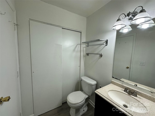 bathroom featuring hardwood / wood-style floors, vanity, and toilet