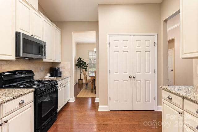 kitchen with light stone countertops, dark hardwood / wood-style flooring, decorative backsplash, and black range with gas cooktop