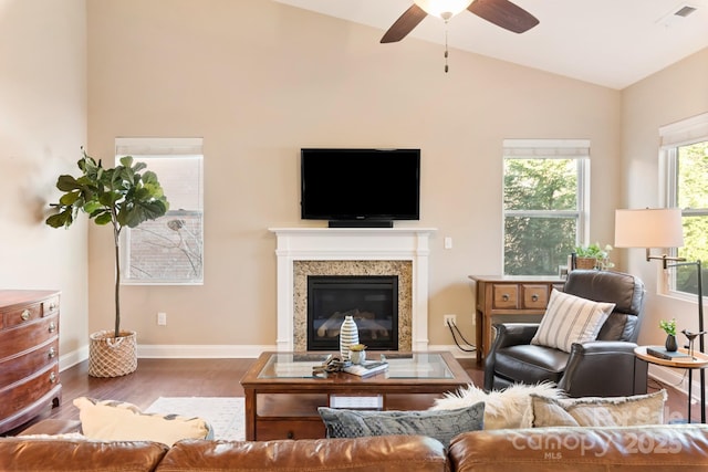 living room with ceiling fan, vaulted ceiling, a fireplace, and hardwood / wood-style flooring