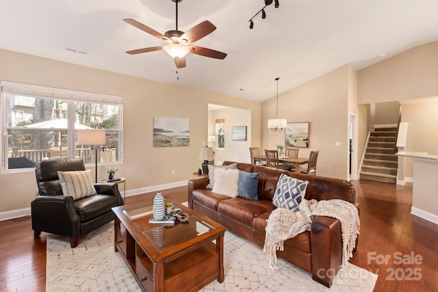 living room with ceiling fan, vaulted ceiling, and light hardwood / wood-style floors