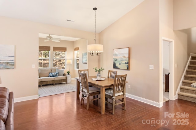 dining room featuring dark hardwood / wood-style flooring, lofted ceiling, and ceiling fan with notable chandelier