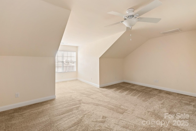 additional living space with ceiling fan, lofted ceiling, and light carpet