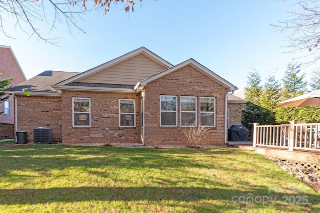 back of property with a deck, central AC, and a yard